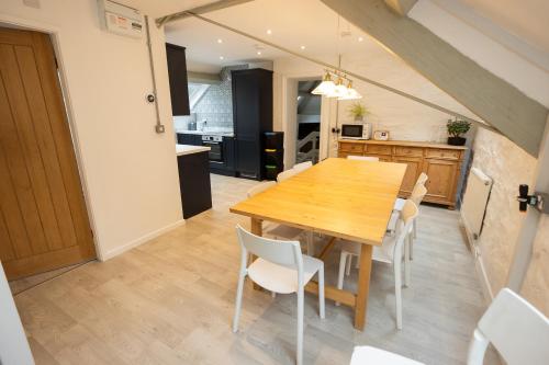 a kitchen and dining room with a wooden table and chairs at The Coach House in Llangollen