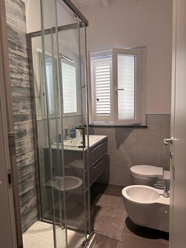 a bathroom with a shower and a sink and a toilet at Leyand exclusive House in Torre del Lago Puccini