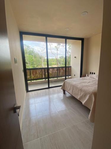 a bedroom with a bed and a view of a balcony at The Empire in Tulum in Tulum