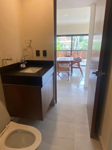 a bathroom with a sink and a toilet and a table at The Empire in Tulum in Tulum