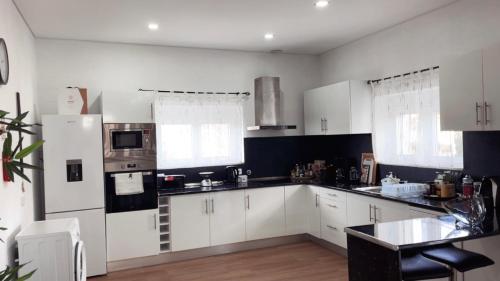 a kitchen with white cabinets and a stove top oven at Casa da Tapada in Torre de Moncorvo