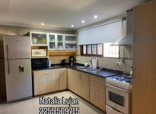 een keuken met een witte koelkast en een fornuis bij Tobias in Villa Gesell