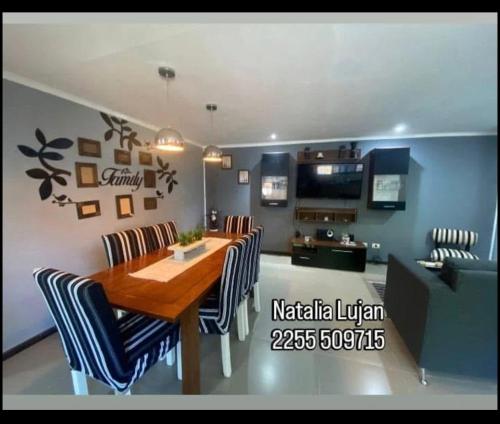 een eetkamer met een houten tafel en stoelen bij Tobias in Villa Gesell