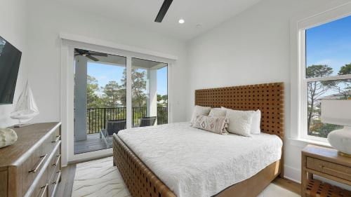 a bedroom with a bed and a balcony at Priv Heated Pool Spa Golf Cart Included 7BDR Sleeps 20 30A Serenity Sands in Santa Rosa Beach
