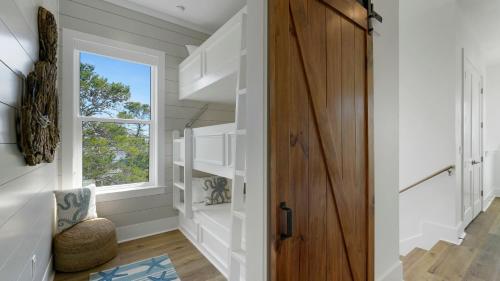 a hallway with a wooden door and a window at Priv Heated Pool Spa Golf Cart Included 7BDR Sleeps 20 30A Serenity Sands in Santa Rosa Beach