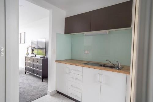 a kitchen with white cabinets and a sink at Bay View Breeze in Lorne
