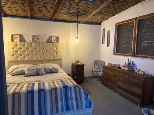 a bedroom with a large bed and a wooden dresser at Puerto idilio beach resort in Isla Grande