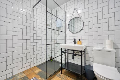 a bathroom with a sink and a glass shower at New Slick Finnieston Pad w/ Free Parking in Glasgow