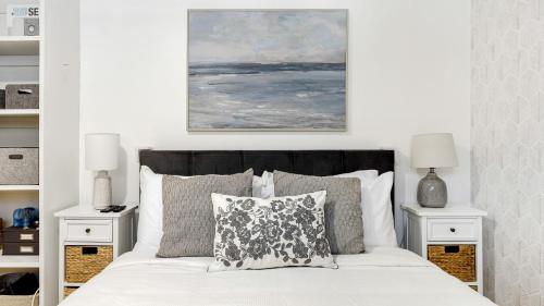 a bedroom with a white bed with two night stands at Oceanfront Gem w Balcony Pool Hot Tub Carbon Beach Access Bluewater Haven by AvantStay in Malibu