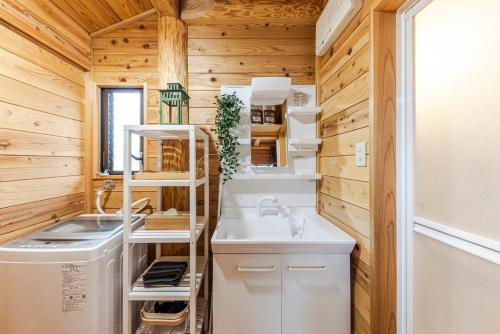 Una pequeña cocina con fregadero y lavadora. en AMANA Villa 101, en Amakusa