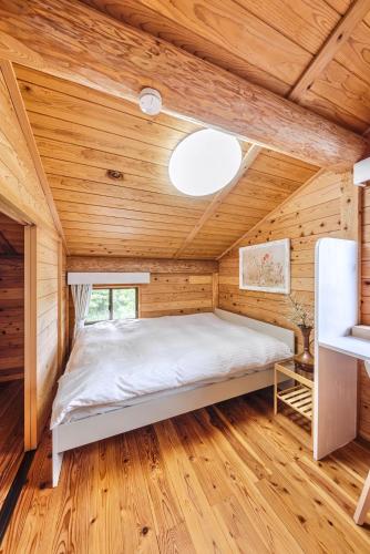 a bedroom with a bed in a room with wooden walls at AMANA Villa 101 in Amakusa