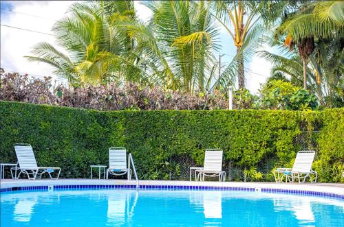 two chairs and a swimming pool in a resort at Plantation Hale on Kauai Steps from the Ocean in Kapaa