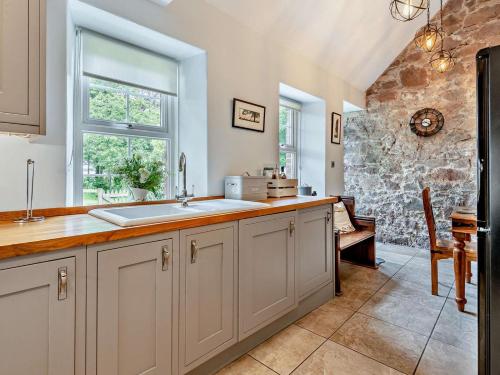 a kitchen with a sink and a stone wall at 2 Bed in Mindrum oc-50973 in Crookham