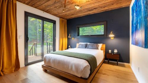 a bedroom with a bed and a large window at Modern Catskills Escape w Open Living Steam Shower Hot Tub w Mountain Views Minutes from Woodstock Trails Suncliff Vista in Shokan