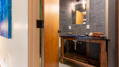 a bathroom with a sink and a mirror at Modern Catskills Escape w Open Living Steam Shower Hot Tub w Mountain Views Minutes from Woodstock Trails Suncliff Vista in Shokan