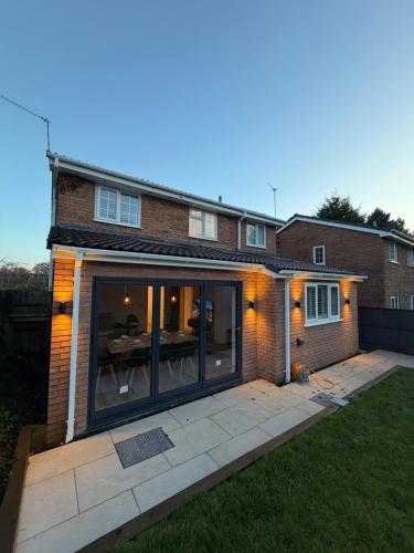 a house with large glass doors on the front of it at Luxury House, Great Location in Redditch - Contractors - Families - Groups - Relocators - Sleeps 9 in Bentley