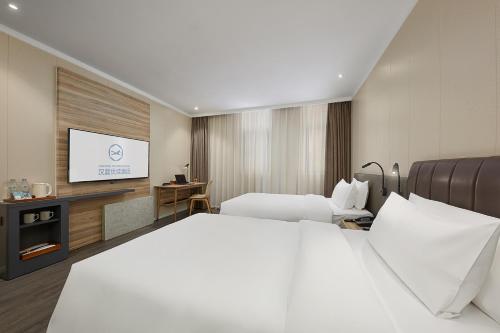 Giường trong phòng chung tại Hanting Premium Hotel Nanjing Jiangpu Research Park