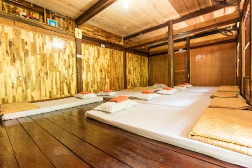 a room with several beds in it with wooden walls at Minh Quang homestay in Ba Be18