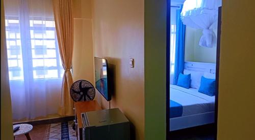 Makasembo furnished apartments one bedroom في كيزيمو: غرفة بها غرفة نوم بها سرير ونافذة