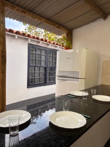uma cozinha com um balcão com placas e um frigorífico em Primo`s 2 Suites & Hostel em Búzios