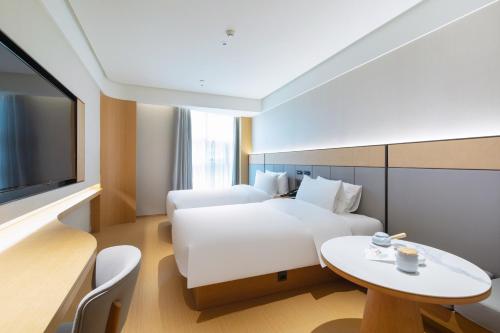 Jiangning全季酒店（南京百家湖1912店）的一间酒店客房,配有一张床铺、一张桌子和一台电视