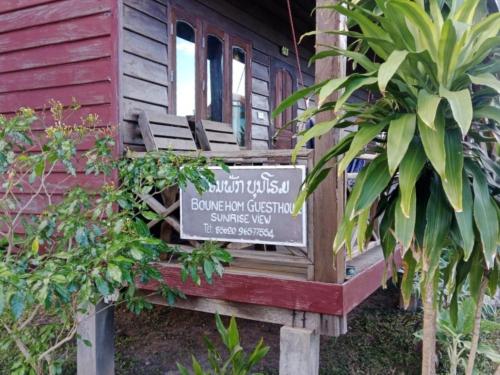 a sign in front of a building with a sign at Boune Hom Guesthouse Sunrise Don Det in Don Det