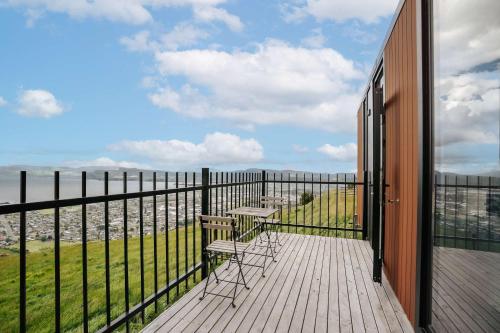 a balcony with two chairs and a view of the ocean at Aorangi Peak Cabins 1 by Tiny Away in Rotorua