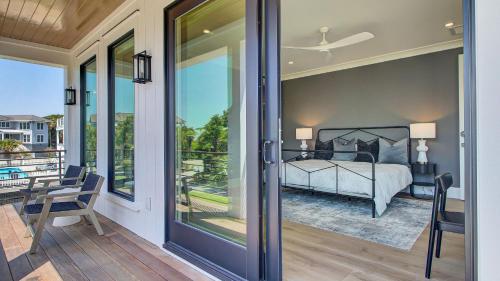 a bedroom with a view of a bed and a balcony at 3 47th Avenue by AvantStay Oceanfront Private Pool View in Isle of Palms
