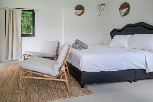 ein Schlafzimmer mit einem Bett und einem Stuhl in der Unterkunft Cozy Seaview Studio 50 Meters From the Beach in Ko Kong Nui
