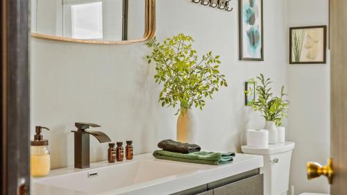 a bathroom with a sink and a mirror and plants at Mountain Mindset by AvantStay Pool Hot Tub Game Room Firepit in Long Pond