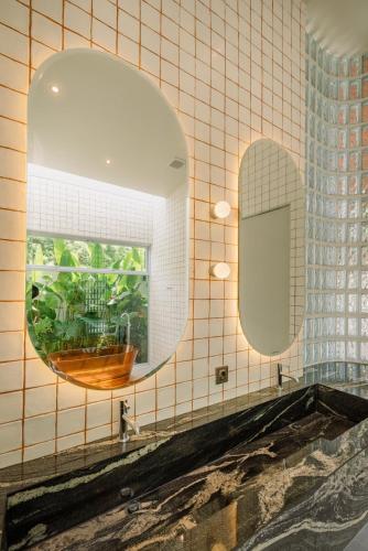 a bathroom with a mirror and a sink at The Outside Design Suites in Uluwatu