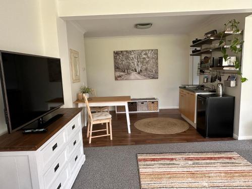 ein Wohnzimmer mit einem TV und einem Schreibtisch in der Unterkunft Tatra Studio Bright - Relax & Explore in Bright