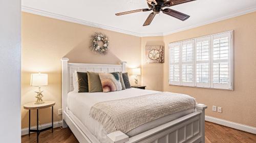 Close to Beach w Patio Resort Amenities The Point at Corniche by AvantStay في دانا بوينت: غرفة نوم بسرير أبيض ومروحة سقف