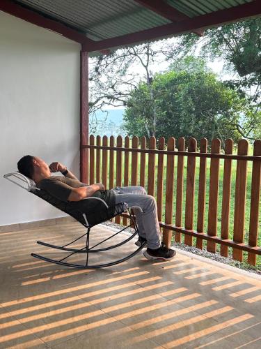 a man laying in a chair on a porch at Finca hotel VillaLuna in Mesetas
