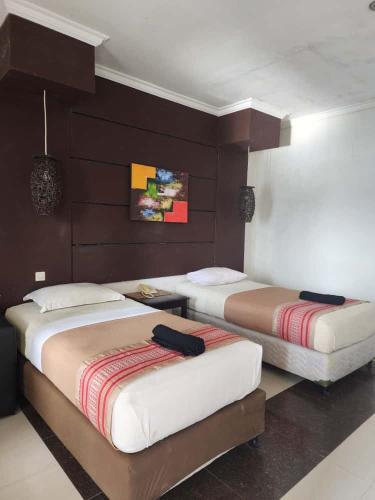 two beds in a hotel room with two at kalaki beach hotel Bima in Daru