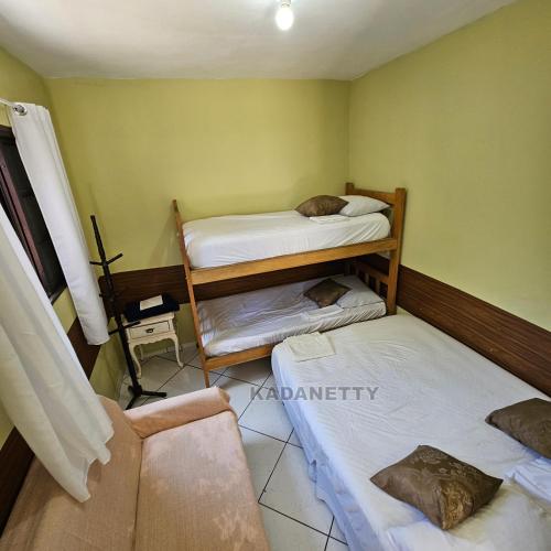 een kamer met 3 stapelbedden bij Casa Ventilada e Confortável, Perto da Rodovia e 2km da Praia in Caraguatatuba