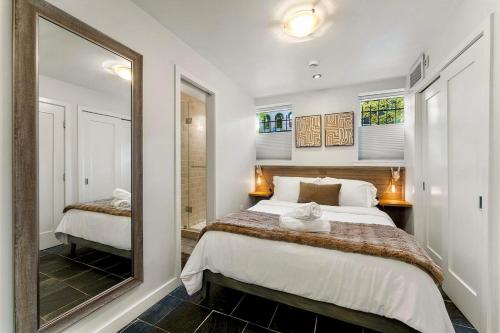 Luxe Logan Circle Escape - Near Downtown DC & Shaw في واشنطن: غرفة نوم مع مرآة كبيرة وسرير
