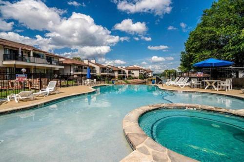 a pool at a resort with chairs and a table at The Cove at Lake Hamilton in Hot Springs
