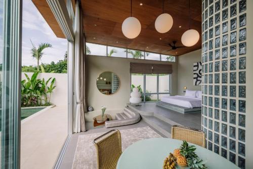 a room with a bed and a table and chairs at The Outside Design Suites in Uluwatu