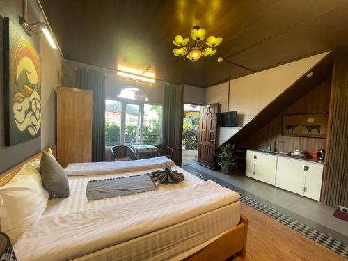 大叻Redhouse Dalat Hotel的一间大卧室,配有一张带吊灯的大床