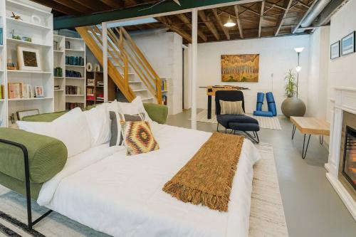 a large white bed in a room with a fireplace at Profs Riverside Haven Art & Style Sleeps 10 in South Bend