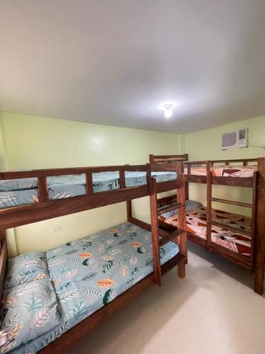 ein Schlafzimmer mit drei Etagenbetten in einem Zimmer in der Unterkunft ACA Transient House in Nasugbu