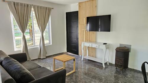 Complejo Ebenezer في San Ignacio: غرفة معيشة مع أريكة وتلفزيون