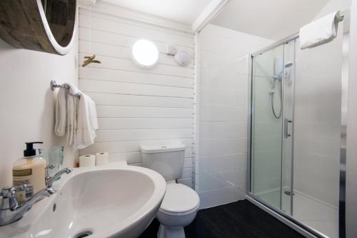 ein Bad mit einem Waschbecken, einem WC und einer Dusche in der Unterkunft The cabin in Truro