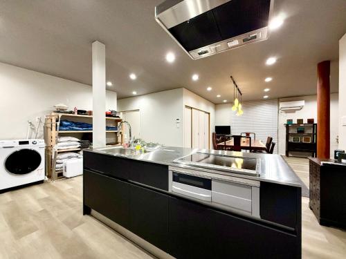 a large kitchen with a sink and a stove at Villa MAEUMー熱海絶景の棟貸しヴィラ BBQとペレットストーブ体験 最大13名追加料金なし in Atami