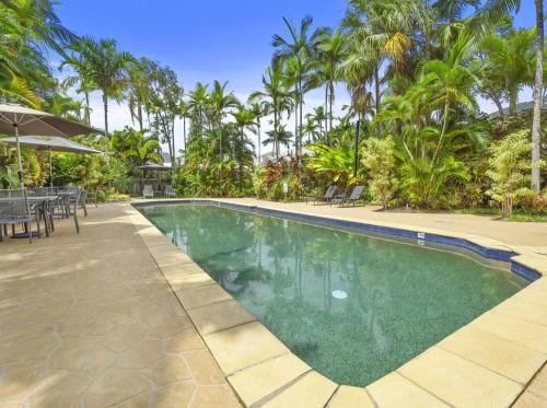 a swimming pool in a resort with palm trees at The Villas Palm Cove-PRIVATE POOL in each villa in Palm Cove