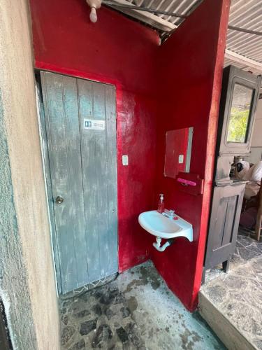 un bagno con un lavandino e una parete rossa di Sunset guest house a San Juan del Sur