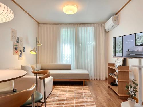a living room with a couch and a tv at Modern 203 Stay in Seoul