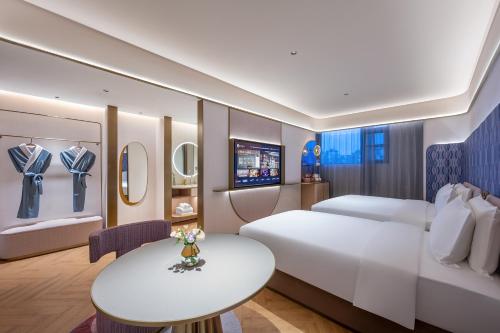 a hotel room with a bed and a table at Qingzhou Ancient City Minxin Hotel in Qingzhou