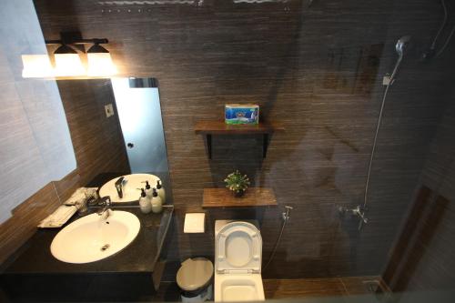 a bathroom with a sink and a toilet and a mirror at Tehya Villa in Da Nang